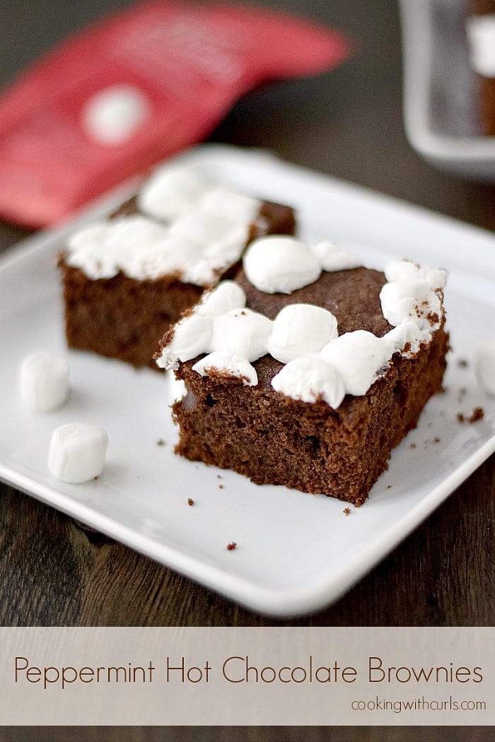 Mini marshmallow topped brownies sitting on a square white plate.
