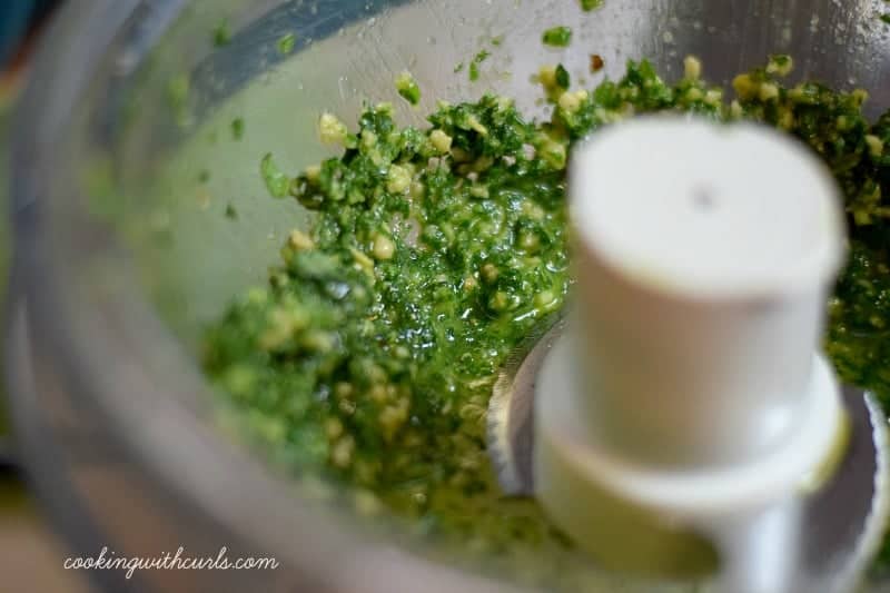 Blended basil pesto in the bowl of a food processor.