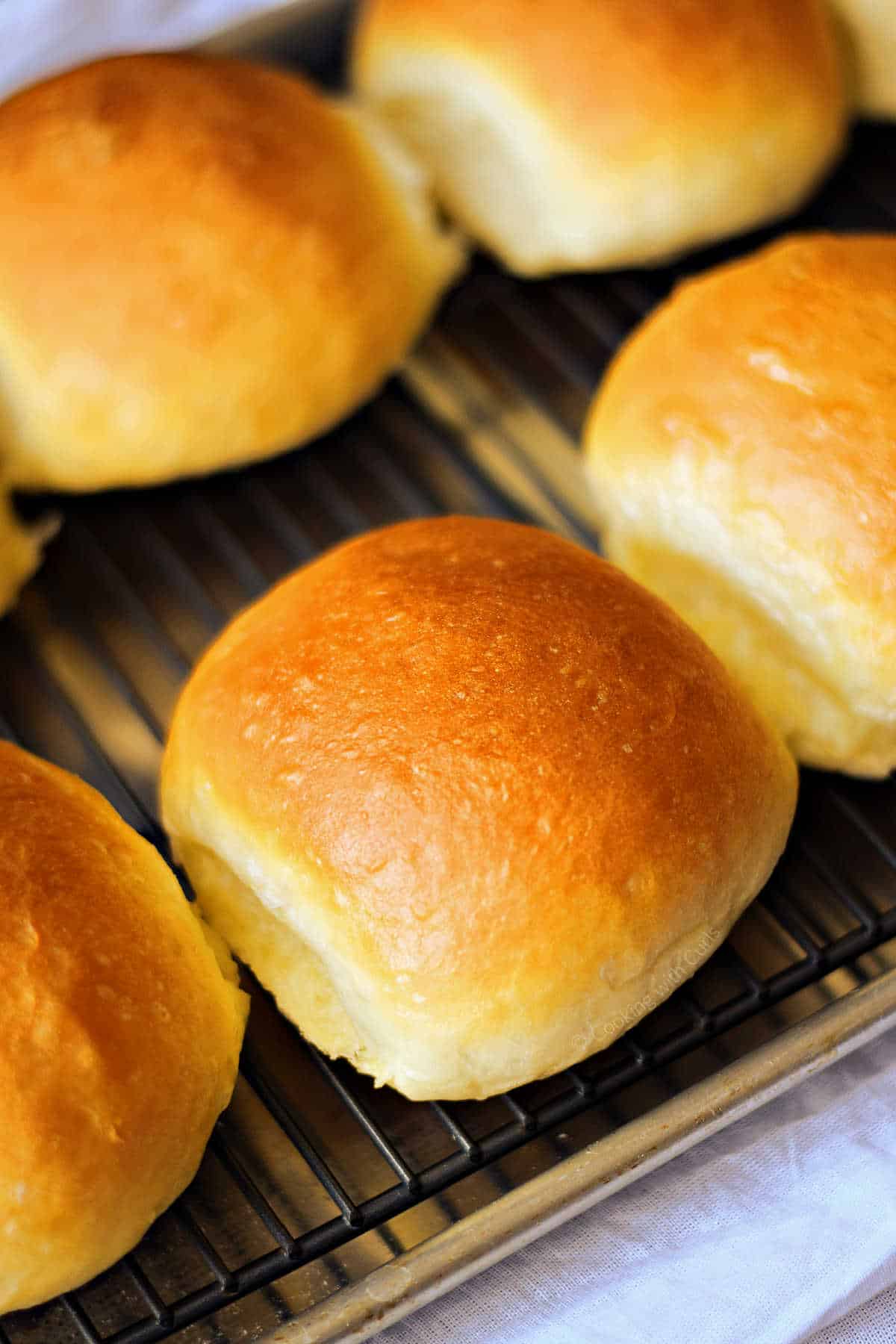 Four hamburger buns on a wire cooking rack.