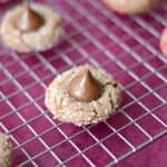 Chocolate Peanut Butter Kisses Cookies on a wire rack over a dark pink napkin