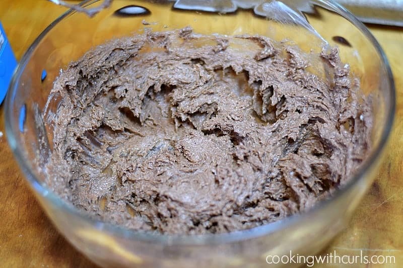 Chocolate Peanut Butter Kisses Cookies dough in a large, glass bowl