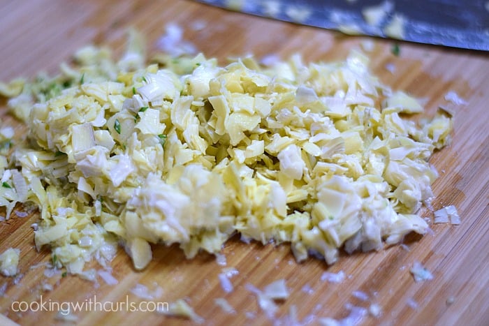 diced artichokes on a wooden cutting board
