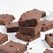 Sweet potato brownies stacked and spread around on a marble background.