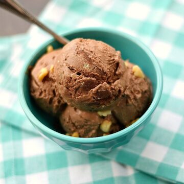 chocolate walnut ice cream in a turquoise bowl sitting on a turquoise and white checkered napkin