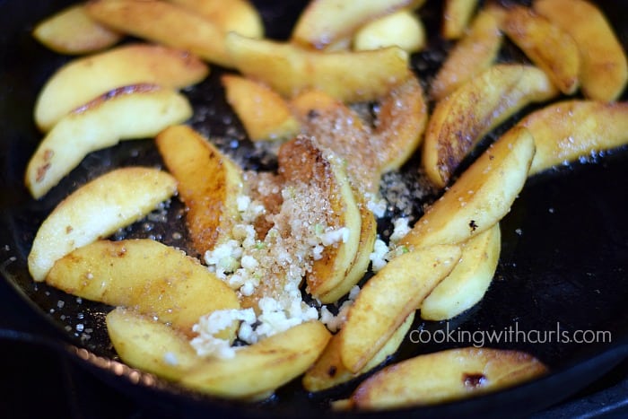Apple wedges, sugar, and minced garlic in a cast-iron skillet.