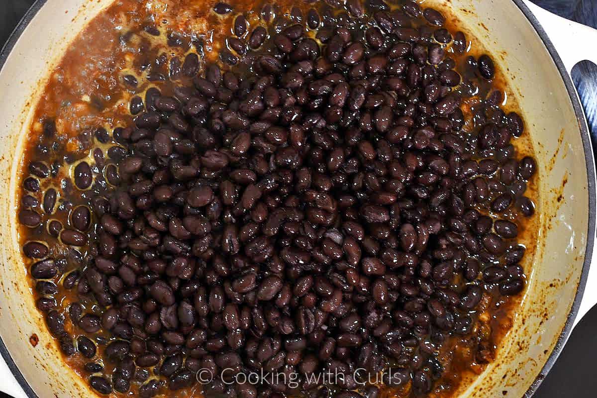 Black beans and water added to the onion mixture in a large skillet. 