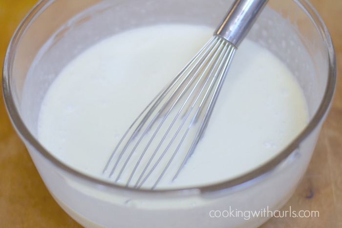 Piña Colada Ice Cream mixture whisked together in a large glass bowl.