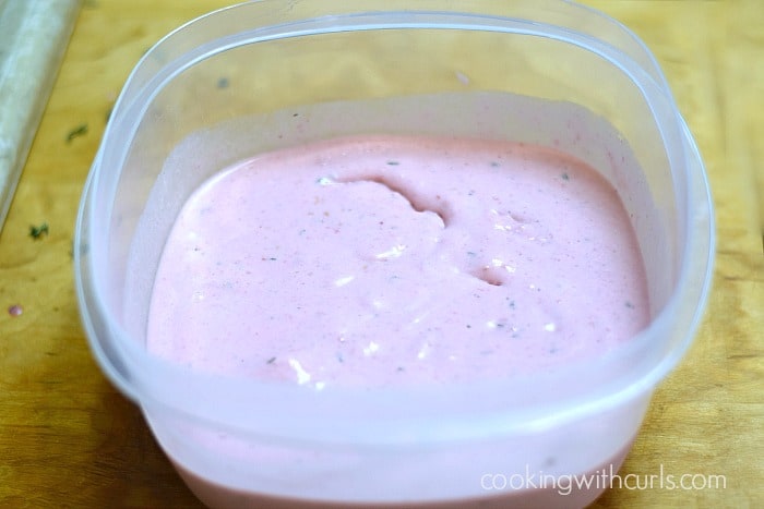 Raspberry Thyme Ice Cream in a plastic freezer container.