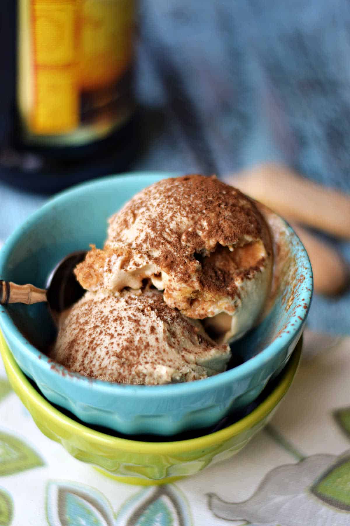 Two scoops of tiramisu ice cream in two stacked ice cream bowls.