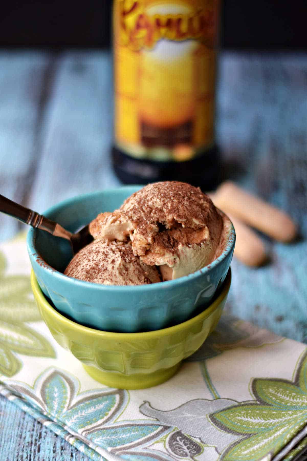 Tiramisu ice cream in stacked bowls in front of a bottle of Kahlua.