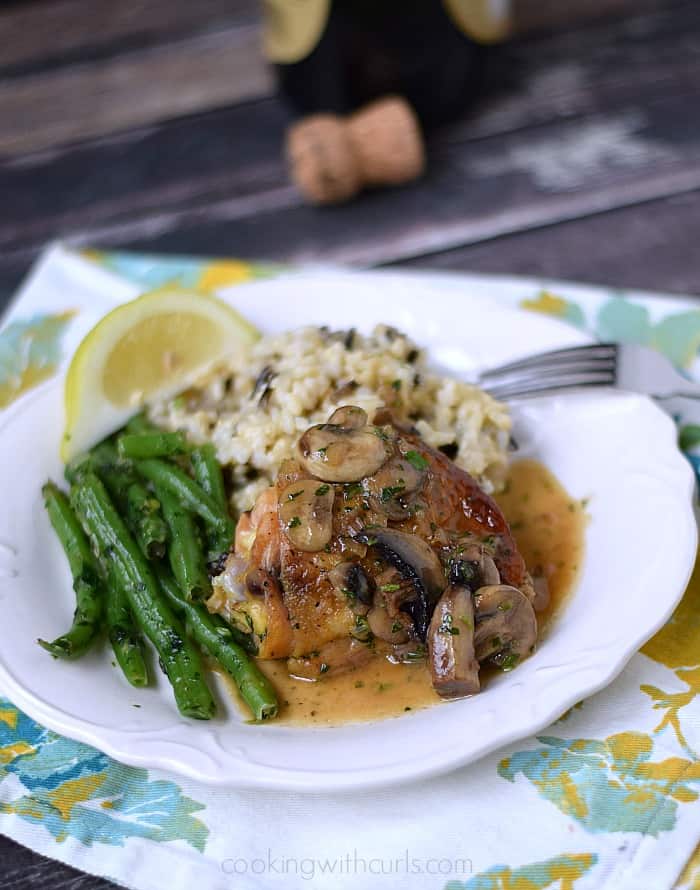 Chicken au Champagne on a plate with brown rice and green beans.