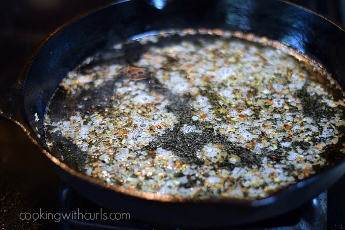 Champagne and shallots in a cast iron skillet.