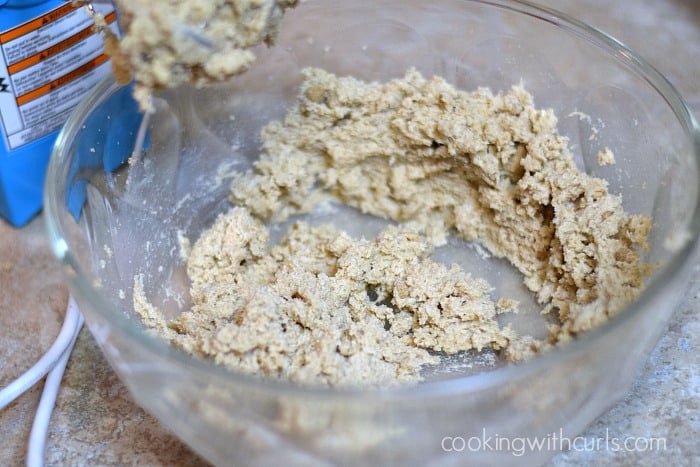 Butter, oats, and sugar mixed together in a large bowl with a hand mixer.
