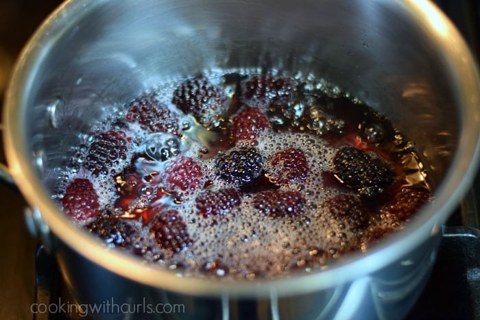 Blackberries, water and sugar simmering in a saucepan.