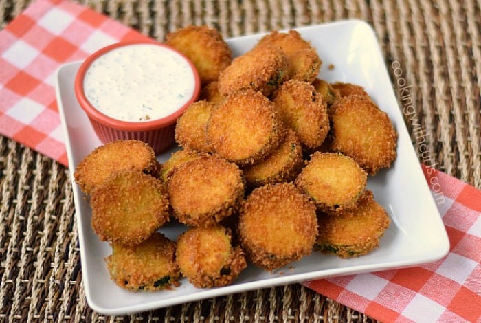 Fried zucchini and a bowl of ranch dressing on a square white plate.