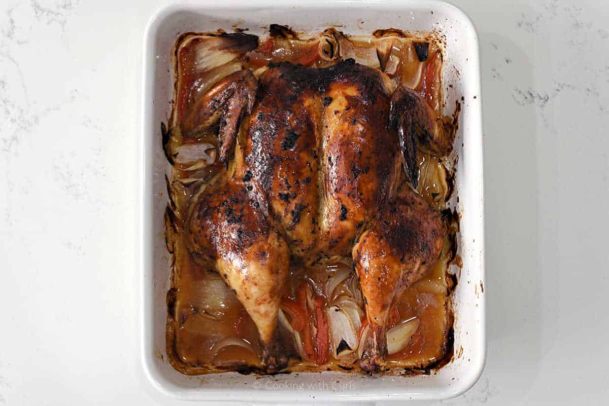 Roast spatchcock chicken in a baking dish.