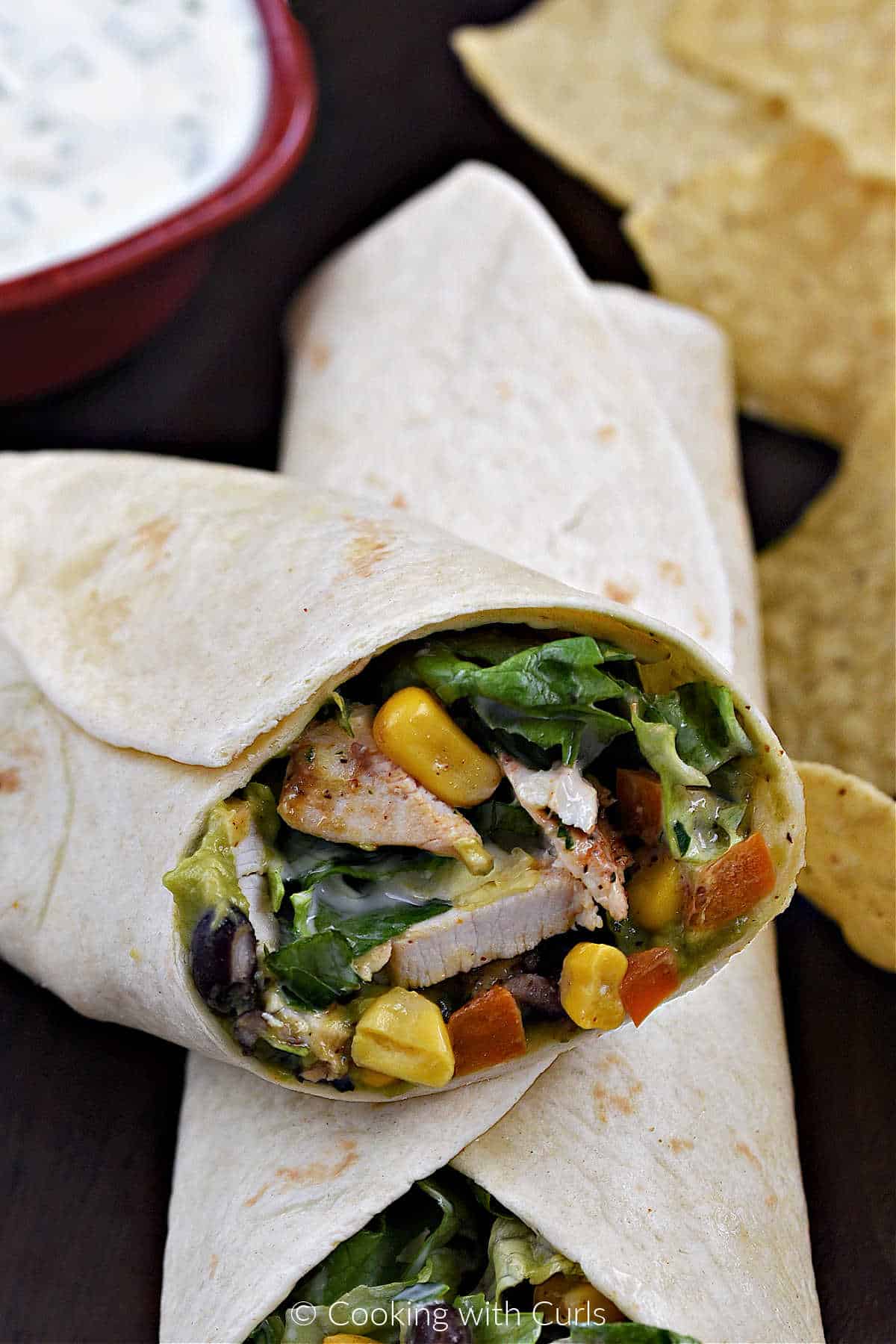 Southwest Chicken Wraps cut in half and stacked on each other with tortilla chips in the background.