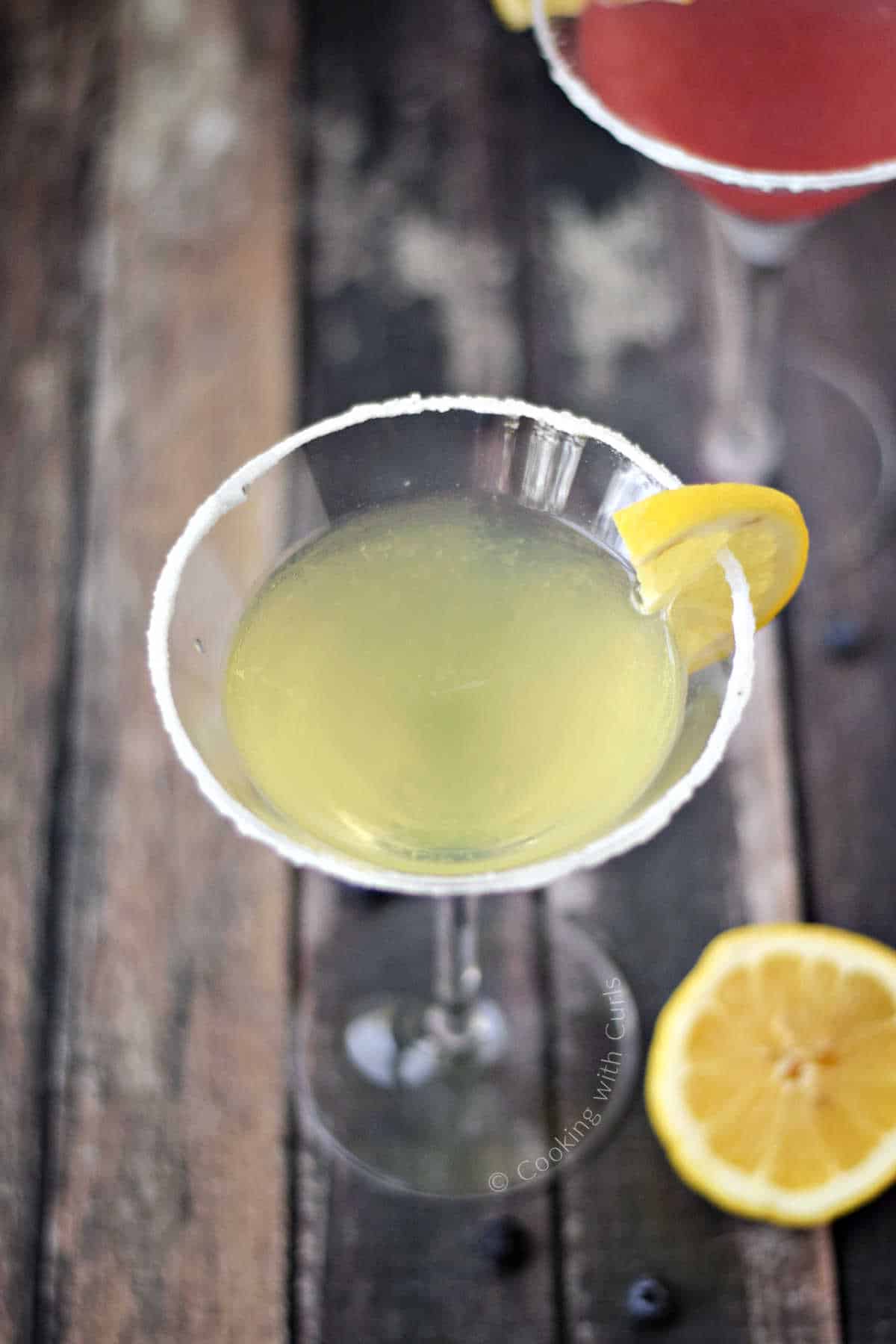 a lemon drop martini and a huckleberry lemon martini in sugar rimmed martini glasses.