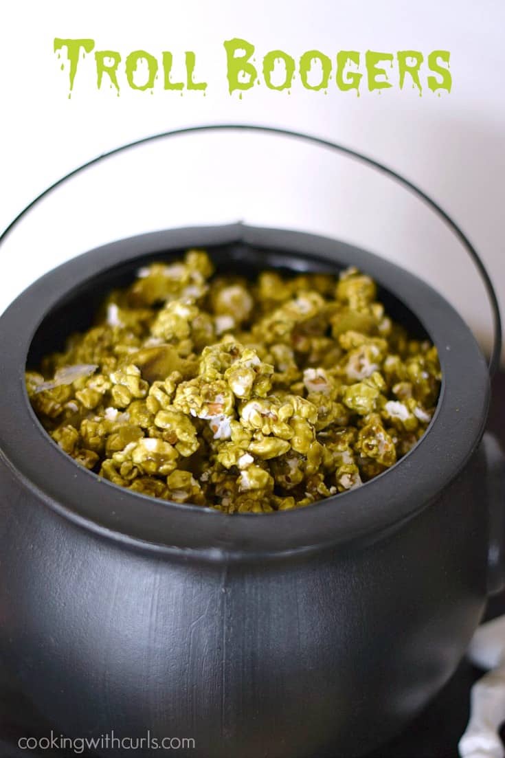 A black cauldron filled with dark green Troll Boogers popcorn