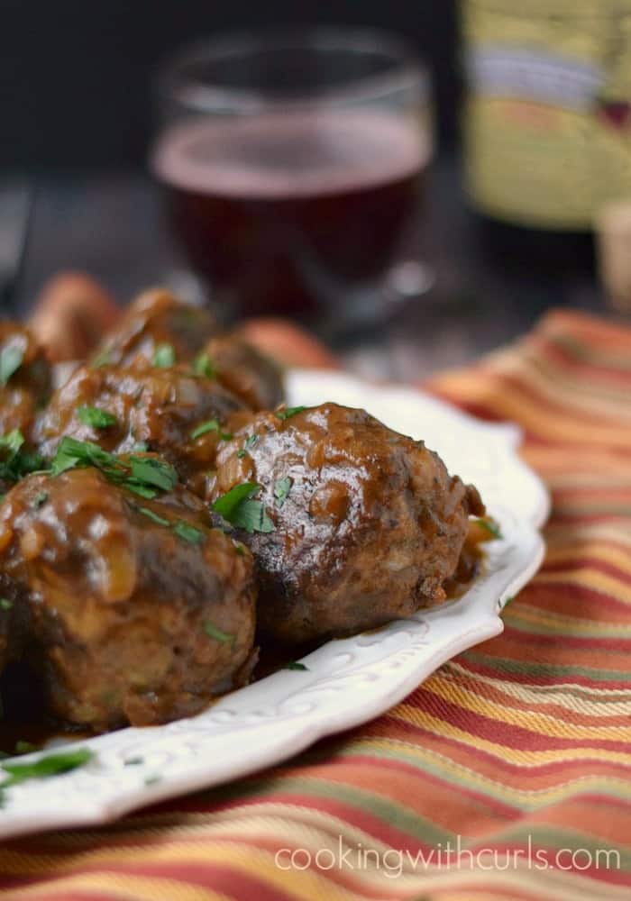 meatballs on a white platter sitting on a fall colored napkin.