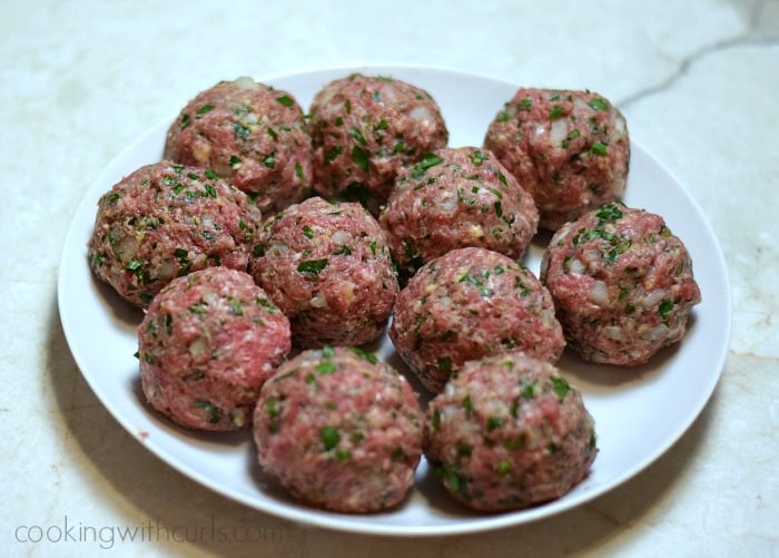 Eleven large meatballs on a large plate.