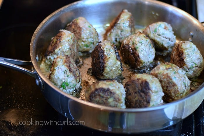 Meatballs browned in melted butter in a large skillet.