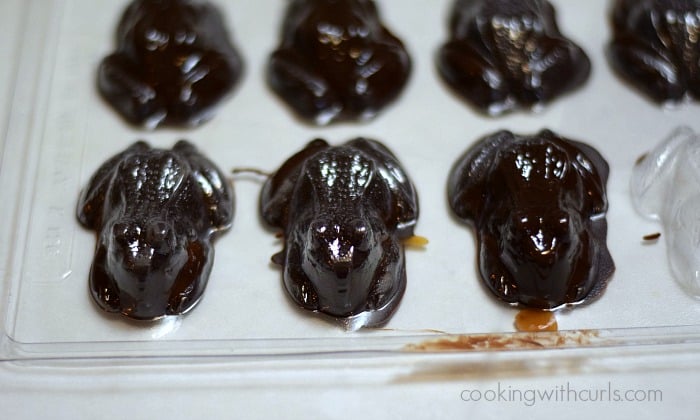 Chilled chocolate frogs tapped on a counter top to remove from the mold.