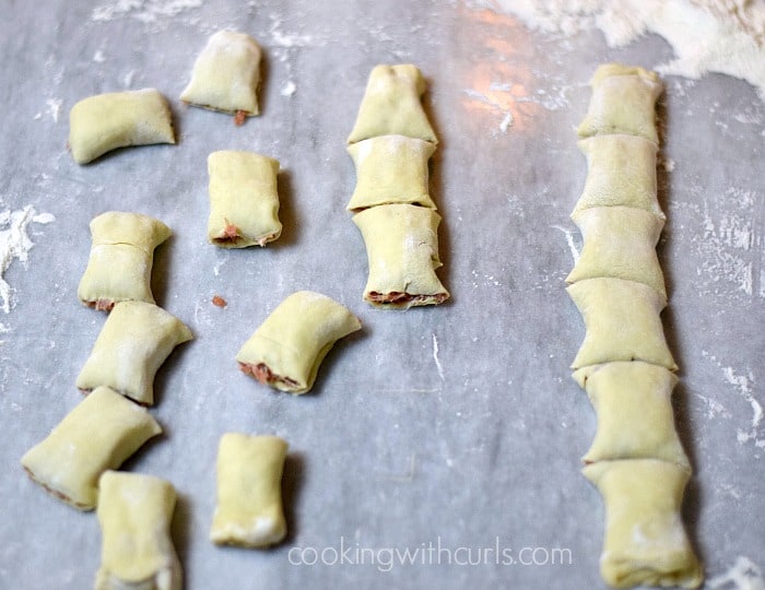 Seventeen cut Puff Pastry Sausage Rolls on a marble board.