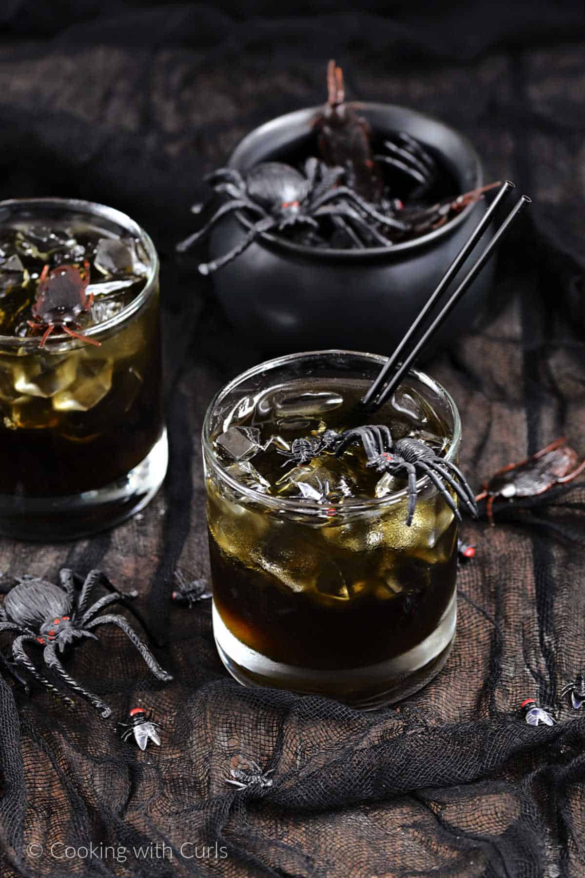 Dark cocktails with ice cubes and plastic spiders, flies, and roaches.