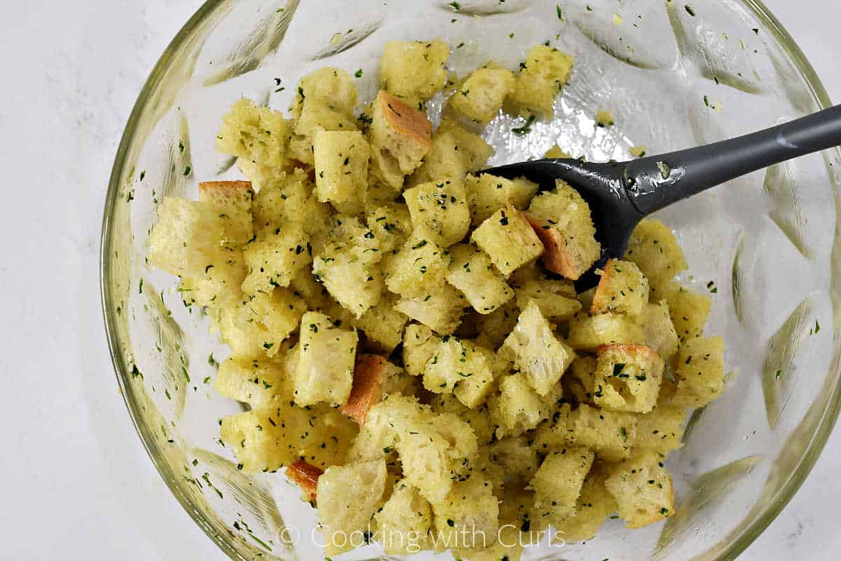 Bread-cubes-tossed-with-herbs-oil-and-butter-in-a-large-bowl.