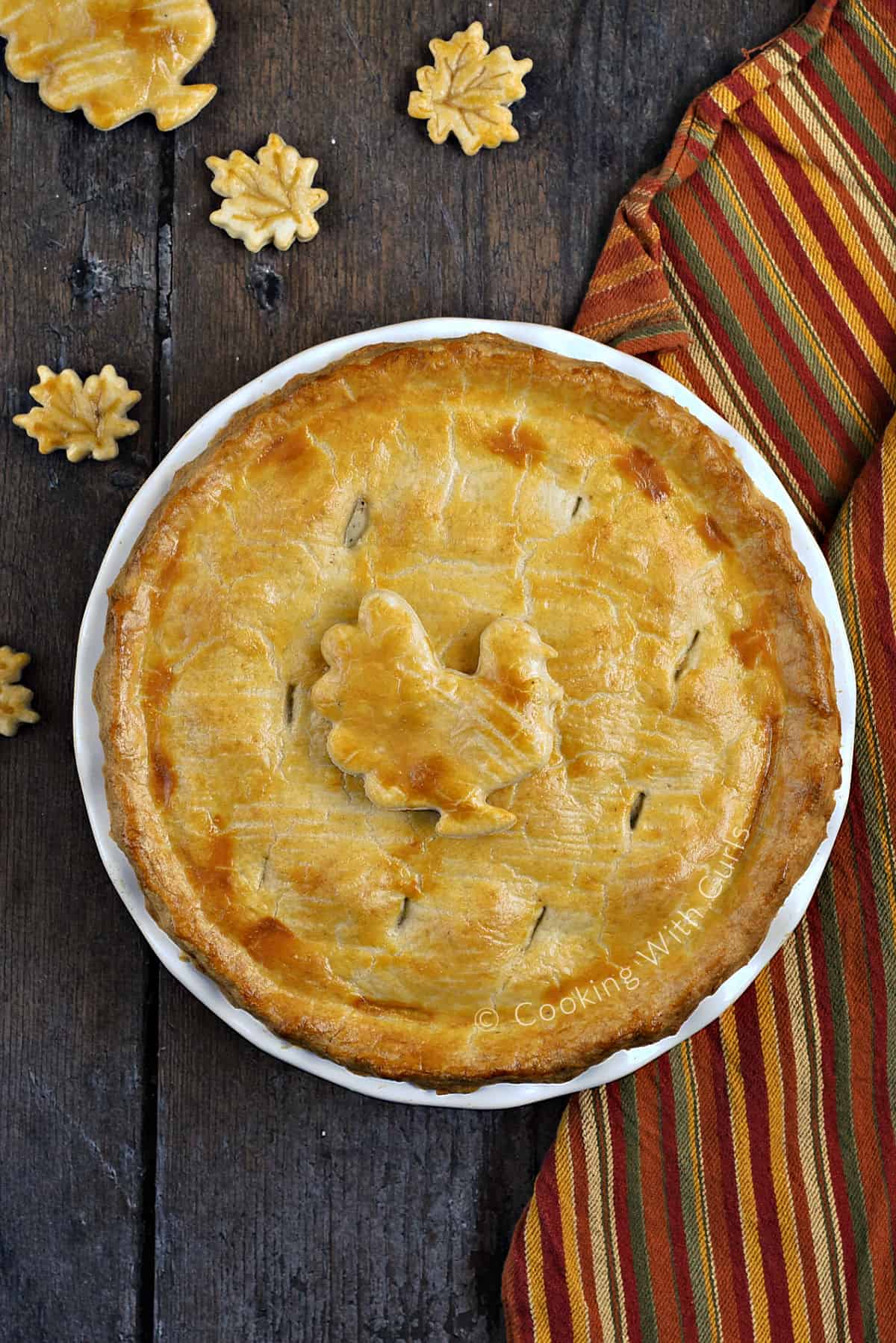 Looking down on a whole turkey pot pie in a pie pan with a cut-out turkey decoration in the center.
