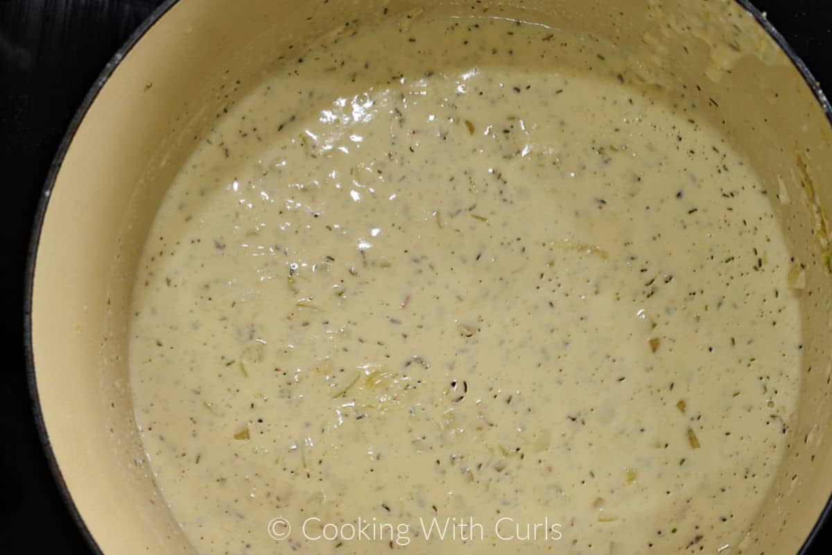 Creamy herb sauce mixed together in a Dutch oven. 