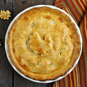 Looking down on a whole turkey pot pie recipe topped with a turkey shaped crust cookie.