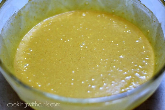 Pumpkin puree, eggs, sugar, and coconut milk mixed in a large bowl.