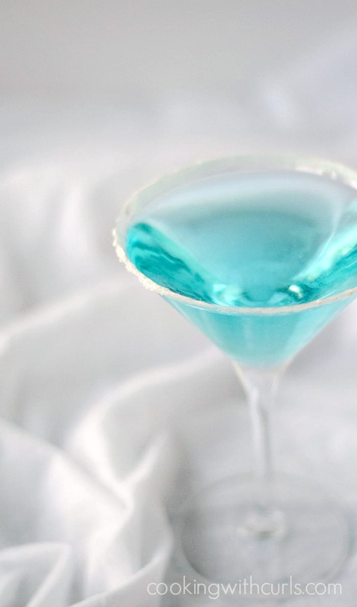 Frozen Inspired blue cocktail in a sugar-rimmed glass.
