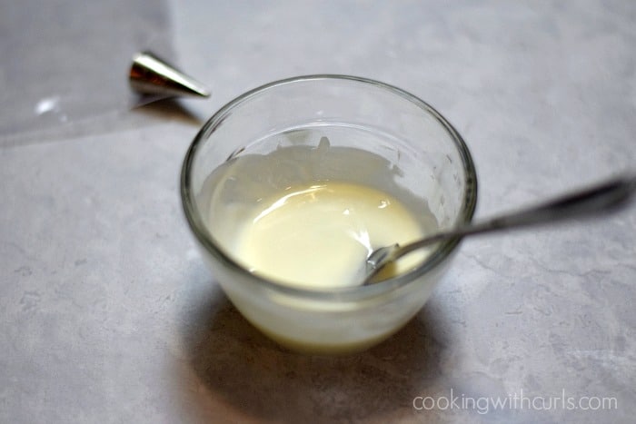 Melted white chocolate in a small glass ramekin.