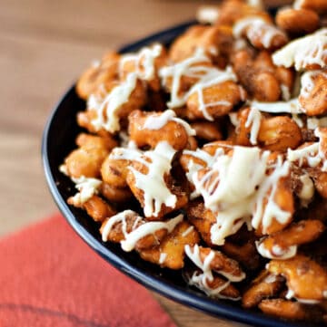 Pretzel Goldfish crackers mixed with cinnamon sugar and drizzled with white chocolate in a bowl next to a football napkin.