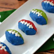 Six OREO cookie balls shaped footballs recipe on a rectangle serving platter.