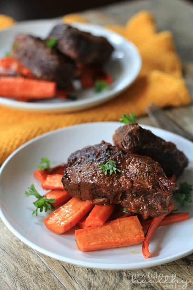 Balsamic-Short-Ribs with carrots and red bell pepper strips on a white plate.