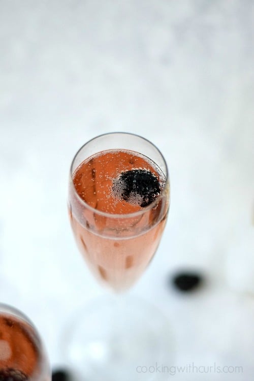 Looking down into a champagne glass filled with Chamobord® Royale  and a fresh blackberry.