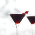 Cherry Cheesecake Martinis sitting in front of a snowy window
