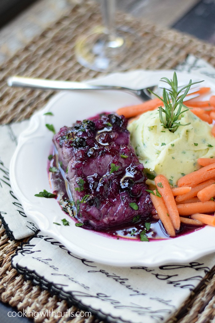 Huckleberry-Glazed-Salmon-with-Goat-Cheese-Whipped-Potatoes and baby carrots on a scalloped white plate.