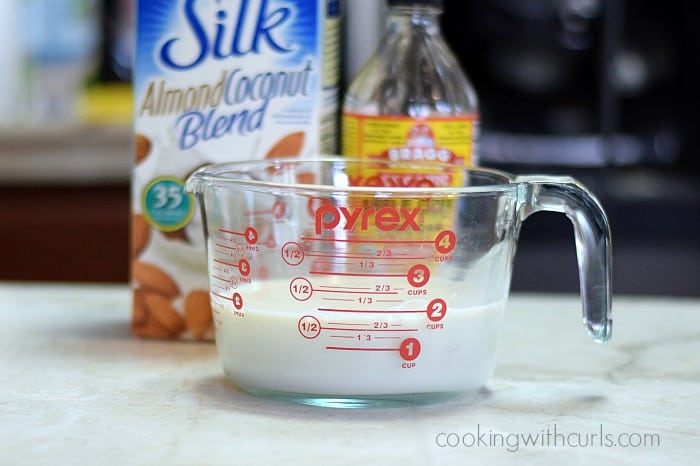 Coconut milk mixed with apple cider vinegar in a large measuring cup.