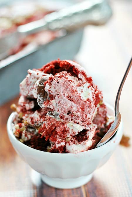 Red Velvet Cheesecake Ice Cream in a small bowl with a spoon sticking up.