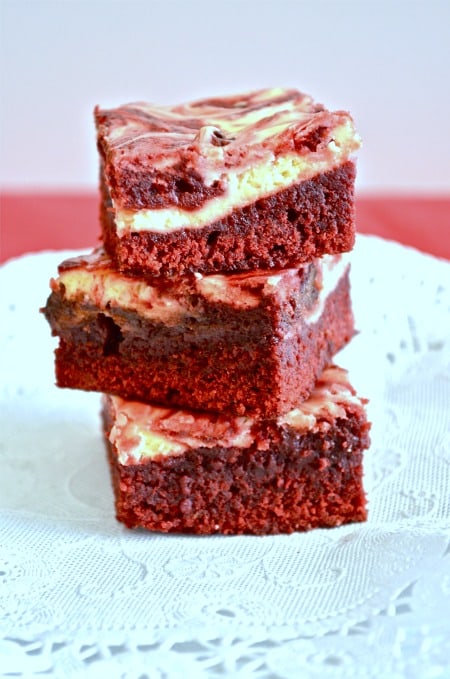 Three Red Velvet Cream Cheese Brownies stacked on top of each other.