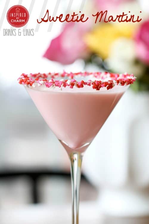 A pink sweetie martini served in a pink heart candy rimmed martini glass.