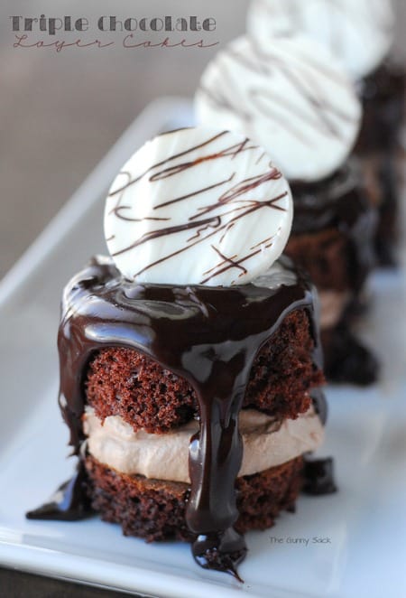 Triple Chocolate Layer Cakes covered in melted chocolate on a plate.