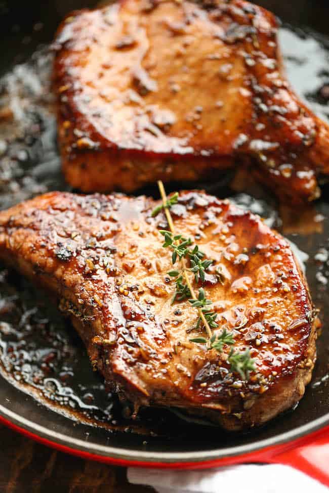 pork chops with sweet and sour glaze in a red skillet.