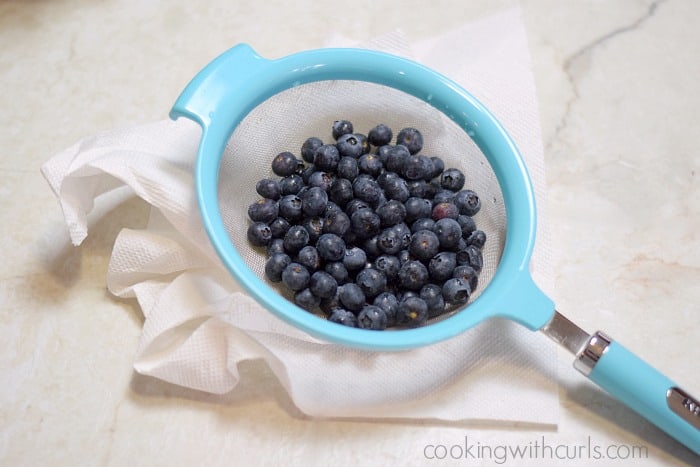 Fresh blueberries rinsed in a strainer an laying on a paper towel.