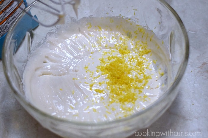 Cream cheese and lemon zest in a large glass bowl.